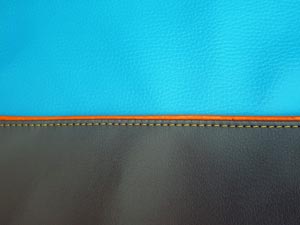 Raues und blaues Kunstleder mit orangener Paspel und Steppnaht